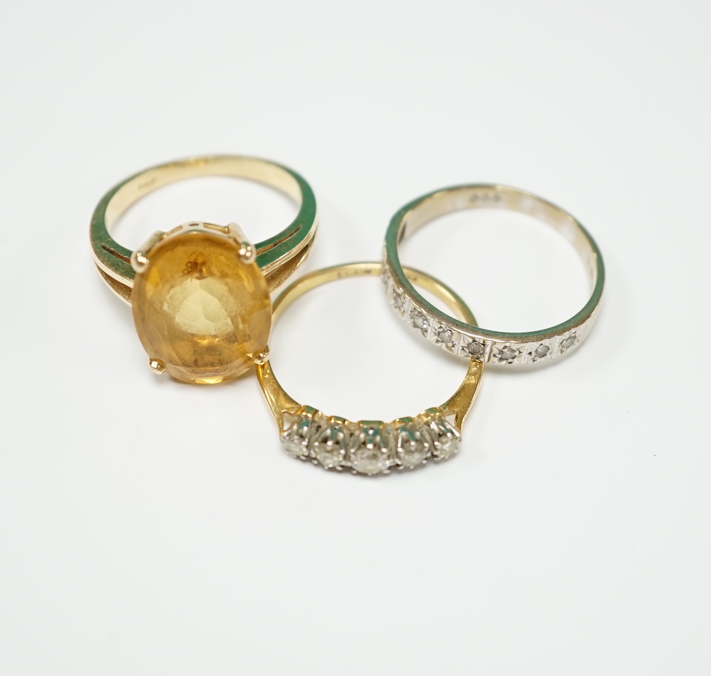An 18ct and graduated five stone diamond set half hoop ring, size P/Q, one other 18ct and diamond chip set half hoop ring, gross weight 4.8 grams and a 14k and citrine set dress ring, gross weight 5.4 grams.